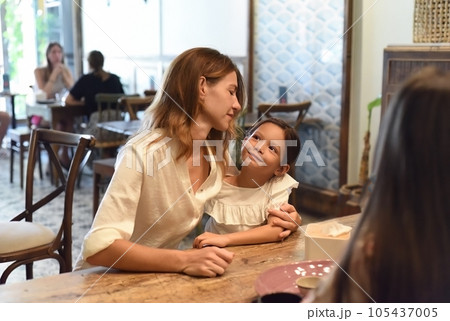 Little girl and her mother hugging and looking at each other in a cafe Little girl and her mother hugging and looking at each other in a cafe 105437005