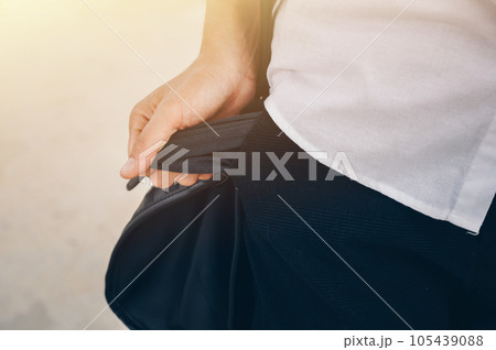Cropped shot of Businesswoman in white shirt turning out and shows empty pockets of her trousers. Conceptual of unemployed woman during Coronavirus recession, economic crisis. Cropped shot of Businesswoman in white shirt turning out and shows empty pockets of her trousers. Conceptual of unemployed woman during Coronavirus recession, economic crisis. 105439088