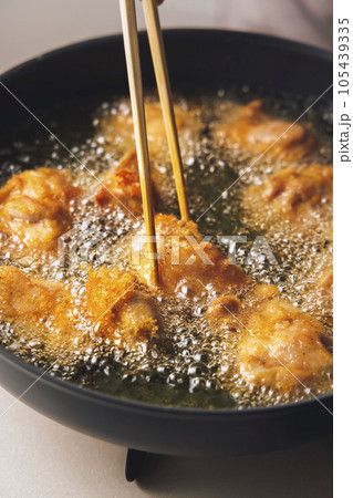 フライパンで揚げている鶏肉の唐揚げ 105439335