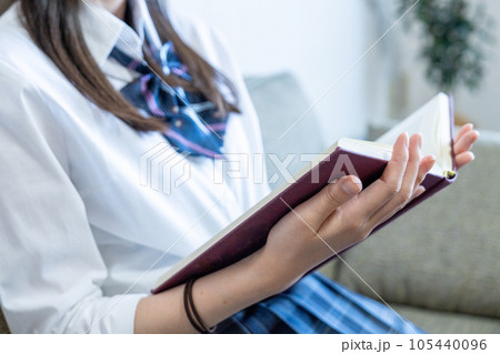 ソファで読書する女子高生【パーツカット】 105440096
