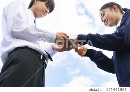 プレゼントを渡す高校生 105441998