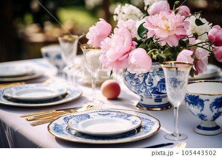 Flower table decorations for wedding dinner. Wedding table set for holiday, event, party, wedding reception in outdoor restaurant. Pink and blue with gold wedding table setting. AI generated 105443502
