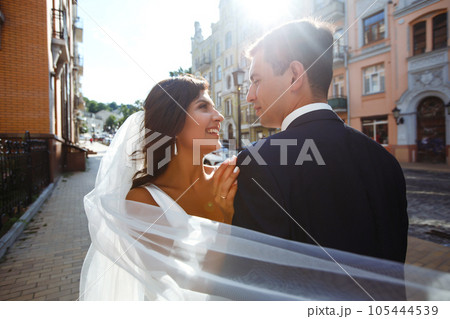 Bride and groom kisses tenderly in the shadow of a flying veil. Together. Wedding. Love. Bride and groom kisses tenderly in the shadow of a flying veil. Together. Wedding. Love. 105444539