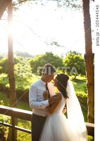Lovely wedding couple at sunset. Bride, groom in wedding attire with bouquet of flowers. Romantic. Lovely wedding couple at sunset. Bride, groom in wedding attire with bouquet of flowers. Romantic. 105444540
