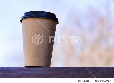 A close-up of a brown cardboard disposable coffee cup. A place for your packaging design. A close-up of a brown cardboard disposable coffee cup. A place for your packaging design. 105445297