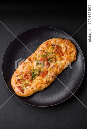 Delicious oven fresh flatbread pizza with cheese, tomatoes, sausage, salt and spices Delicious oven fresh flatbread pizza with cheese, tomatoes, sausage, salt and spices 105445806