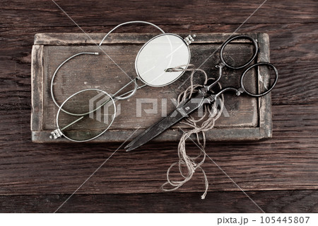 Antique accessories wooden box, old vintage retro scissors and pince-nez. 105445807