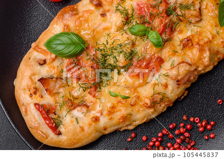 Delicious oven fresh flatbread pizza with cheese, tomatoes, sausage, salt and spices 105445837