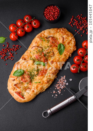 Delicious oven fresh flatbread pizza with cheese, tomatoes, sausage, salt and spices 105445847