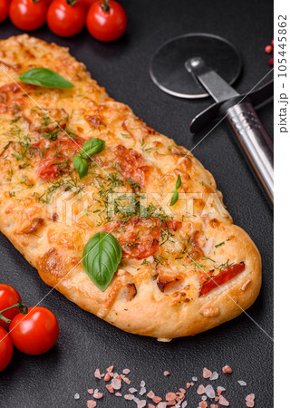 Delicious oven fresh flatbread pizza with cheese, tomatoes, sausage, salt and spices Delicious oven fresh flatbread pizza with cheese, tomatoes, sausage, salt and spices 105445862