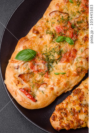 Delicious oven fresh flatbread pizza with cheese, tomatoes, sausage, salt and spices Delicious oven fresh flatbread pizza with cheese, tomatoes, sausage, salt and spices 105445883