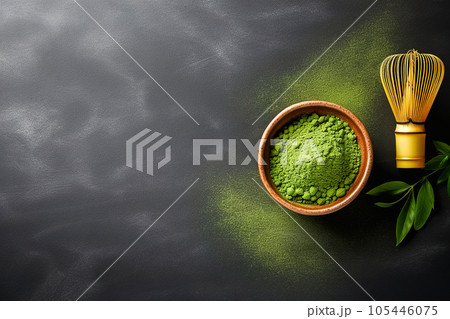 Matcha green tea powder and whisk, on a black background with place for text. Matcha green tea powder and whisk, on a black background with place for text. 105446075