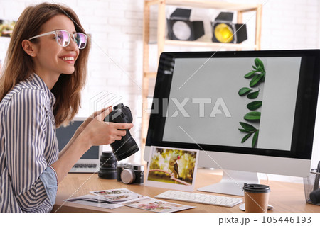 Professional photographer with camera working at table in office 105446193