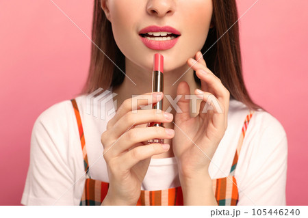 Beauty blogger with lipstick on pink background, closeup Beauty blogger with lipstick on pink background, closeup 105446240