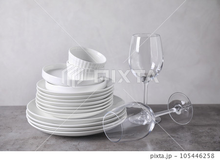 Set of clean dishware on grey table 105446258