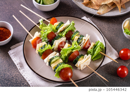 Fresh tomato, cucumber, cheese, tortilla and lettuce canape on a plate 105446342