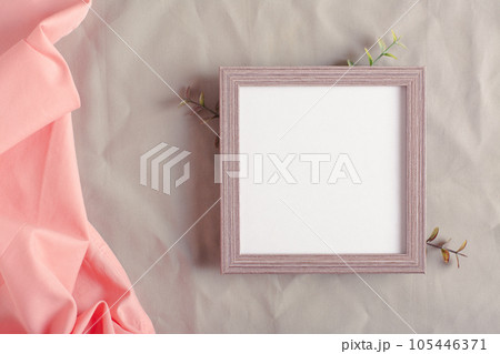 Mockup empty photo frame and branches on green cotton fabric top view 105446371