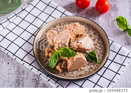 Canned tuna fish meat and basil on a plate on the table 105446375