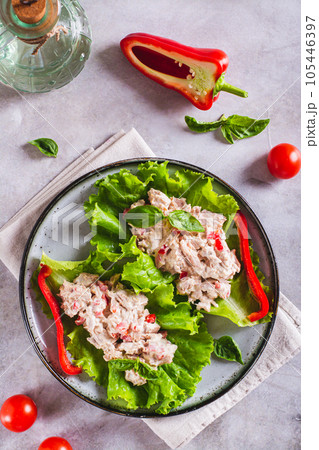 Canned tuna salad with pepper and egg on lettuce leaves on a plate top and vertical view 105446397