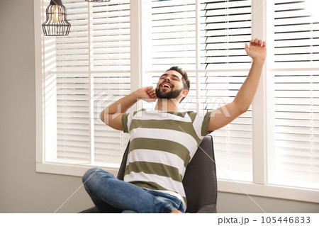 Young man relaxing at home. Peaceful rest 105446833