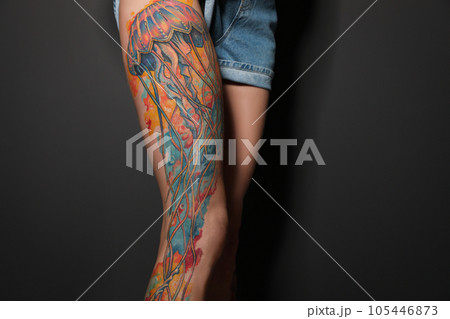 Woman with tattoos on leg against black background, closeup Woman with tattoos on leg against black background, closeup 105446873