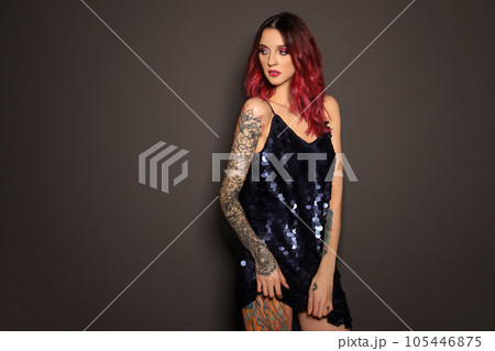 Beautiful woman with tattoos on body against black background Beautiful woman with tattoos on body against black background 105446875