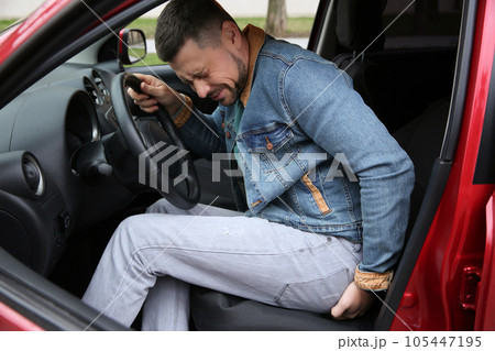 Man suffering from hemorrhoid pain in car Man suffering from hemorrhoid pain in car 105447195