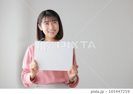 メッセージボードを持つカジュアルな服装の女性_2 メッセージボードを持つカジュアルな服装の女性_2 105447259