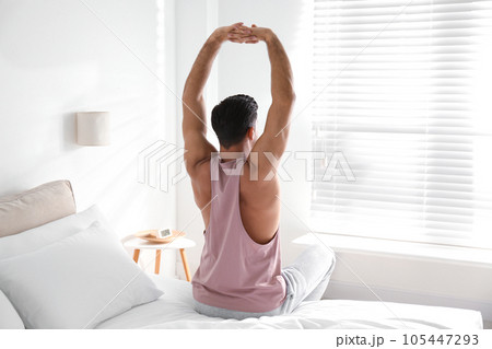 Man awakening on bed at home. Lazy morning 105447293
