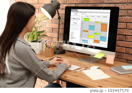 Young woman using calendar app on computer in office Young woman using calendar app on computer in office 105447570