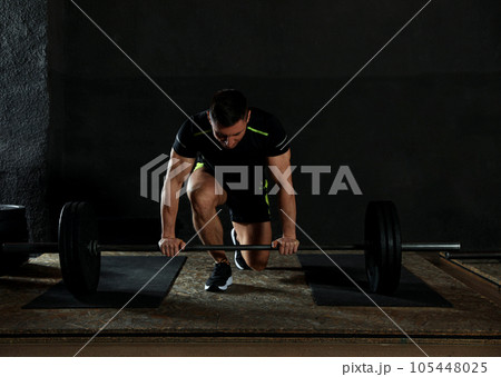 Strong man lifting barbell in modern gym 105448025