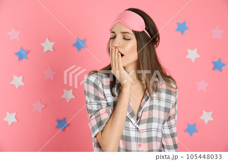 Beautiful woman wearing pajamas and sleep mask on pink background. Bedtime Beautiful woman wearing pajamas and sleep mask on pink background. Bedtime 105448033