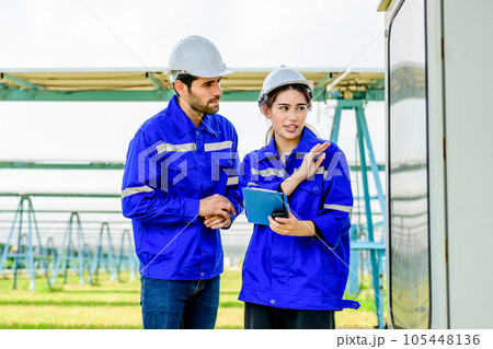 Technicians workers installing solar panels at solar cell farm 105448136