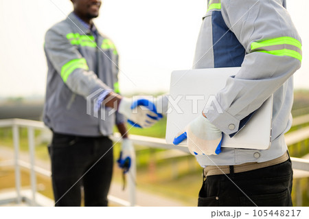 Professional engineers maintaining solar panels on solar cell farm 105448217