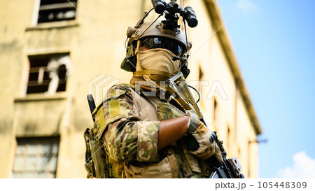 Expert team of soldiers with weapons attacking enemy during military operation, Army soldiers in protective combat uniform, Soldiers with rifle on world war field 105448309