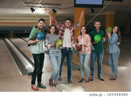 Group of friends with balls in bowling club Group of friends with balls in bowling club 105448480