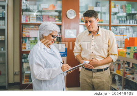 pharmacist is asking about a patient's condition in order to prescribe medication according to the patient's symptoms who come for prescription consultation in a modern pharmacy. 105449405