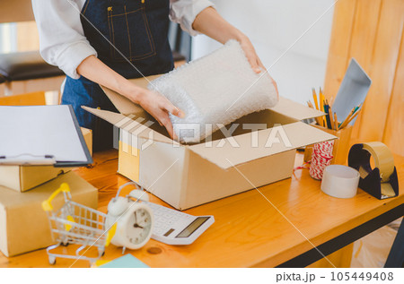 Online small business owners are packing their ordered products into the boxes for their customers based on the concept of online shopping - online shopping. 105449408