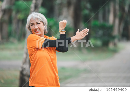 white-haired elderly person exercising in the park early in the morning. 105449409
