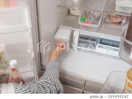 【冷蔵室から給水タンクを出す主婦】 105450242