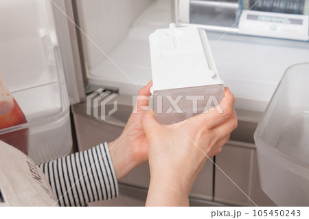 【冷蔵室から給水タンクを出す主婦】 105450243