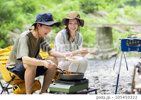 キャンプで焼きそばを作るカップル 105450322