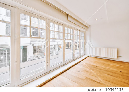 an empty room with wood flooring and large windows looking out onto the street in london, uk stock photo 105451584