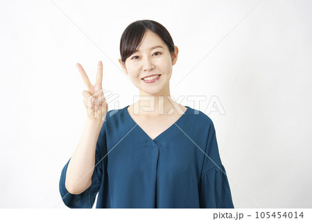 ピースサインするミドルエイジの女性 白背景 ピースサインするミドルエイジの女性 白背景 105454014