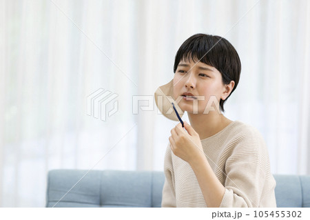 マスクを外す若い女性 105455302