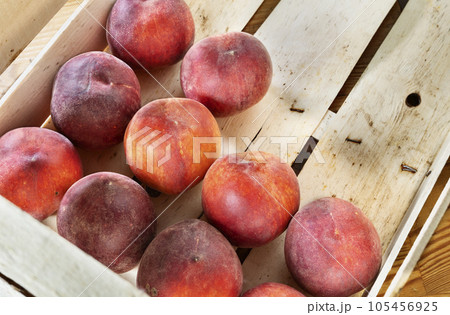 Ripe peaches in wooden box Ripe peaches in wooden box 105456925