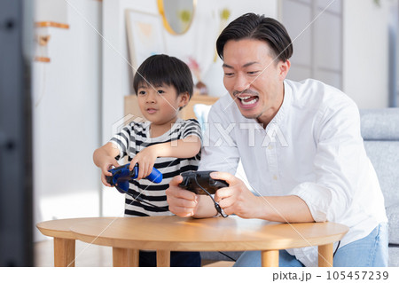 テレビゲームを楽しむ男の子とパパ テレビゲームを楽しむ男の子とパパ 105457239