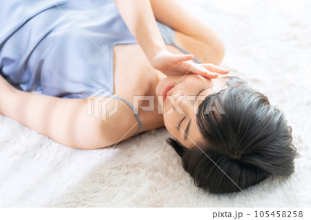 寝転んでスキンケアをする若い女性 105458258