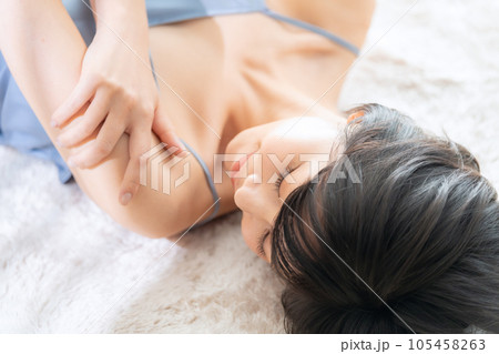 寝転んでスキンケアをする若い女性 105458263