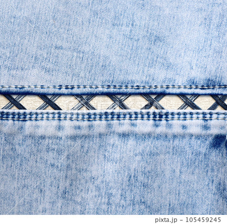 Blue denim background with a seam. Light blue color denim jeans fabric texture. Copy space for text Blue denim background with a seam. Light blue color denim jeans fabric texture. Copy space for text 105459245